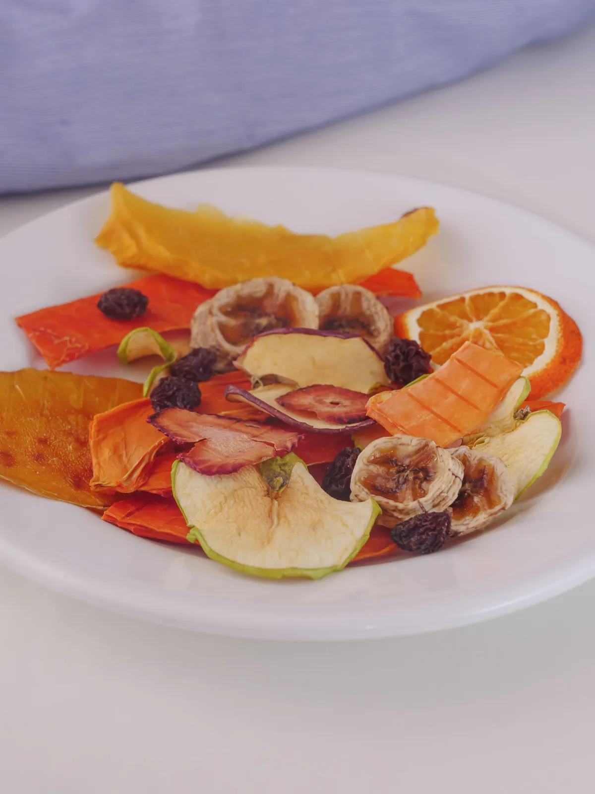 Fette di frutta disidratata su un piatto bianco